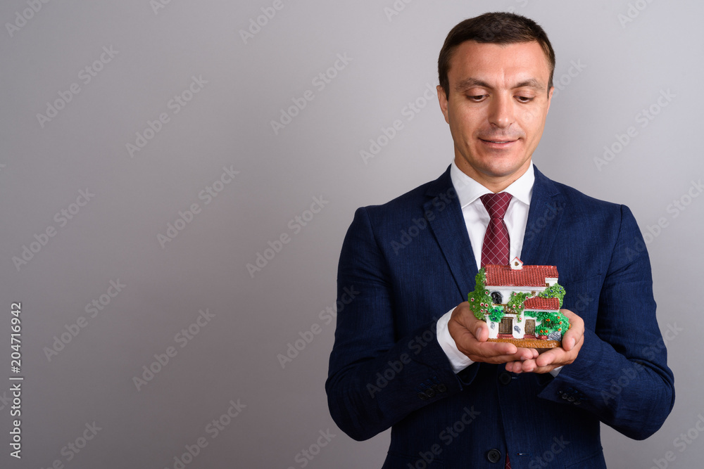 Businessman wearing suit against gray background Businessman wearing suit against gray background