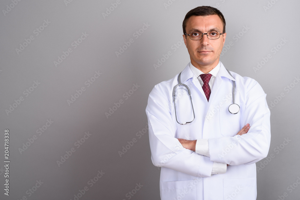 Man doctor wearing eyeglasses against gray background Man doctor wearing eyeglasses against gray background