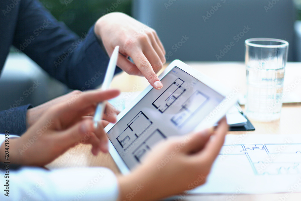 Real-estate agent showing house plans on electronic tablet. Real-estate agent showing house plans on electronic tablet.