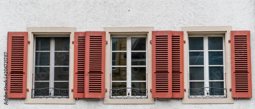 close up view of three windowls with wooden window shutters in red © makasana photo