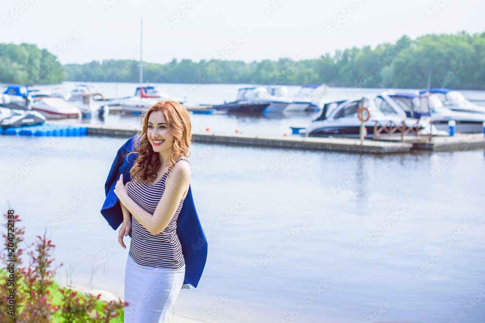 Beautiful fashionable woman enjoying with marine vacation in the yacht club. Outdoor fashion portrait of pretty  woman walking, luxury yacht club, vacation and relax 