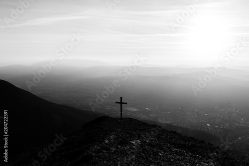Cross on top of Mt. Serrasanta (Umbria, Italy), with sun low on the horizon