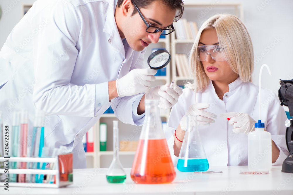 Two chemists having discussion in lab Two chemists having discussion in lab