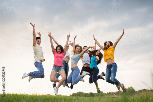 Young people jumping against the sunset sky