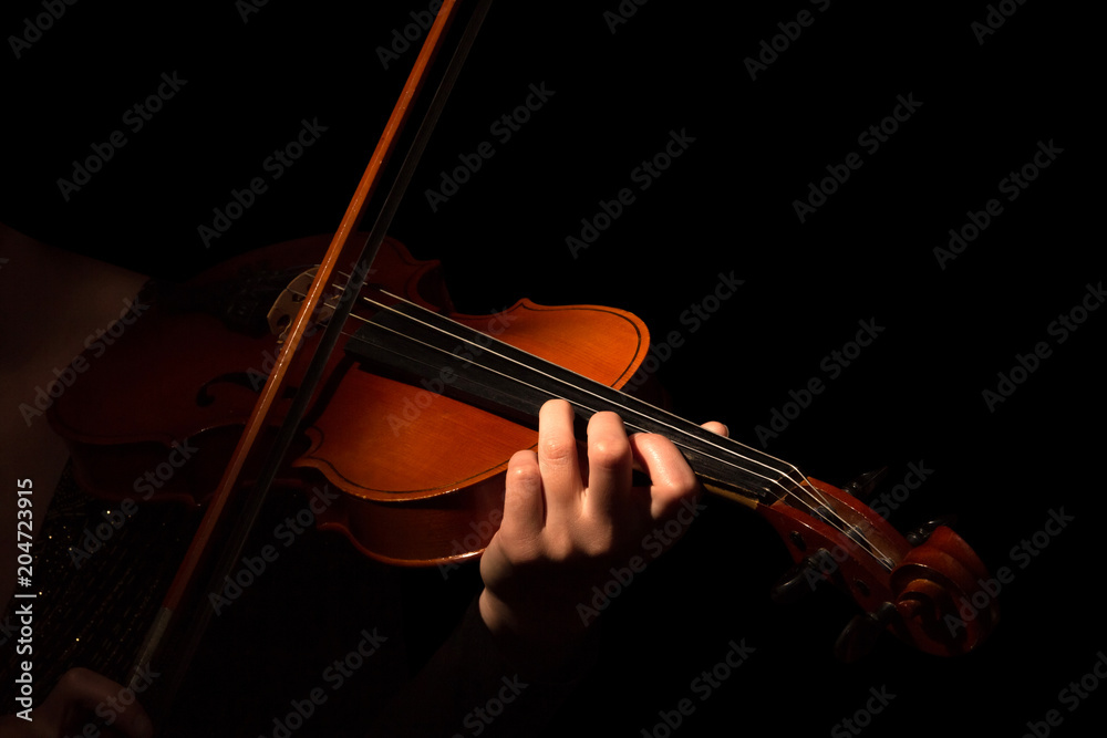 Fototapeta premium Violin and bow in the hands of musician isolated on black