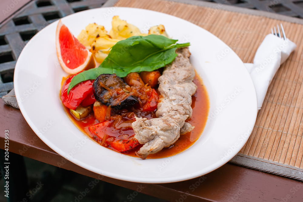 roasted meat with grilled vegetables and juicy sauce on the table roasted meat with grilled vegetables and juicy sauce on the table