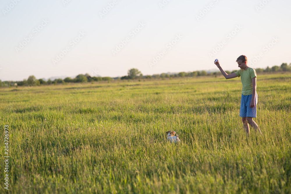 teenager playing with a dog in the nature,