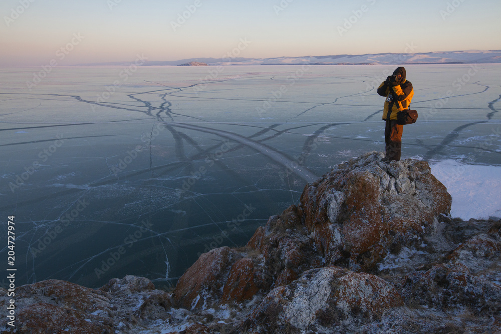 Obraz premium photographer on the frozen shore of lake Baikal