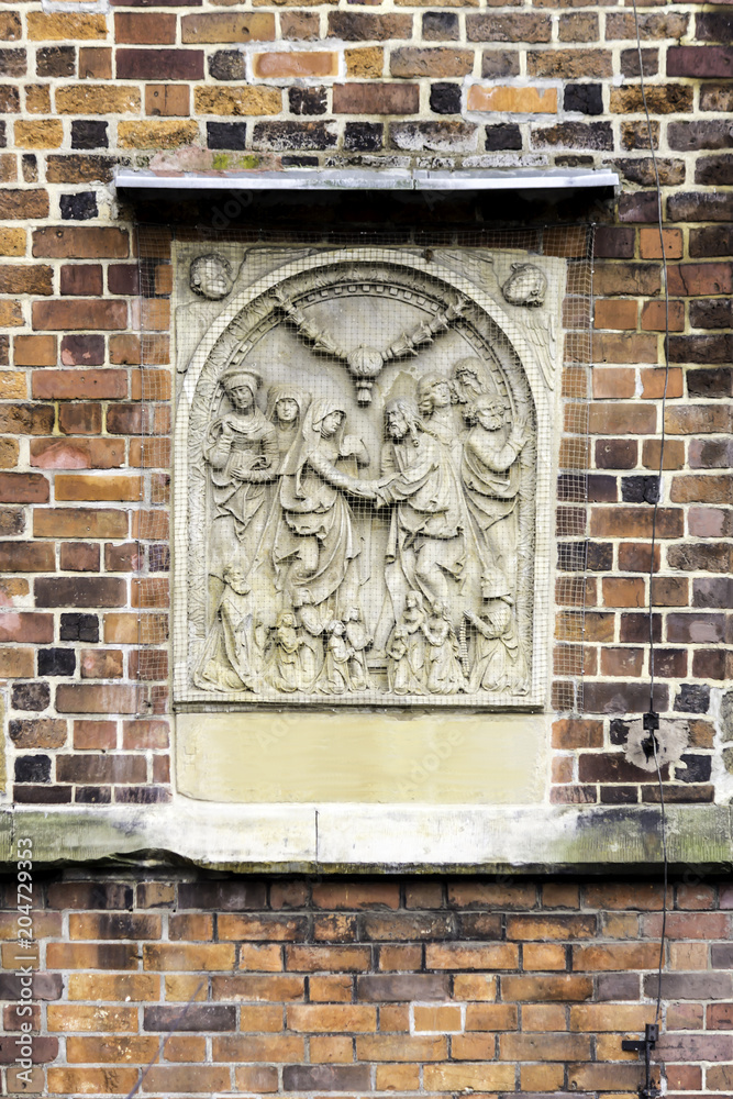 Detail of a brick cathedral in the Gothic style. Carved bas-relief of limestone on the side facade. St.Mary Magdalene Church.Wroclaw,Poland.