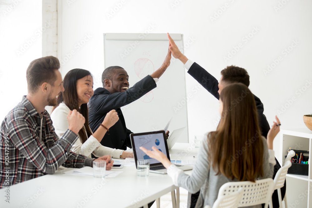 Excited diverse executive colleagues or partners giving high five at ...