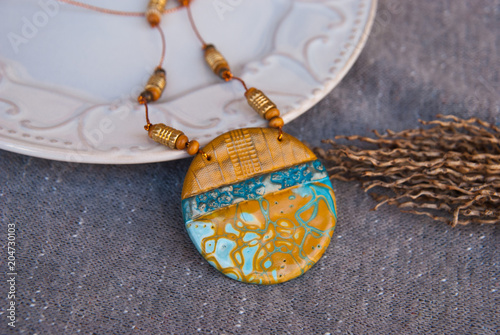 Handmade turquoise and gold pendant. Polymer clay jewelry. Fashion boho necklace background.