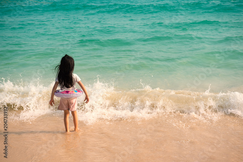 baby  kid girl alone is stand beside strong wave on the beach. Dangerous hazardous Concept. © SP56