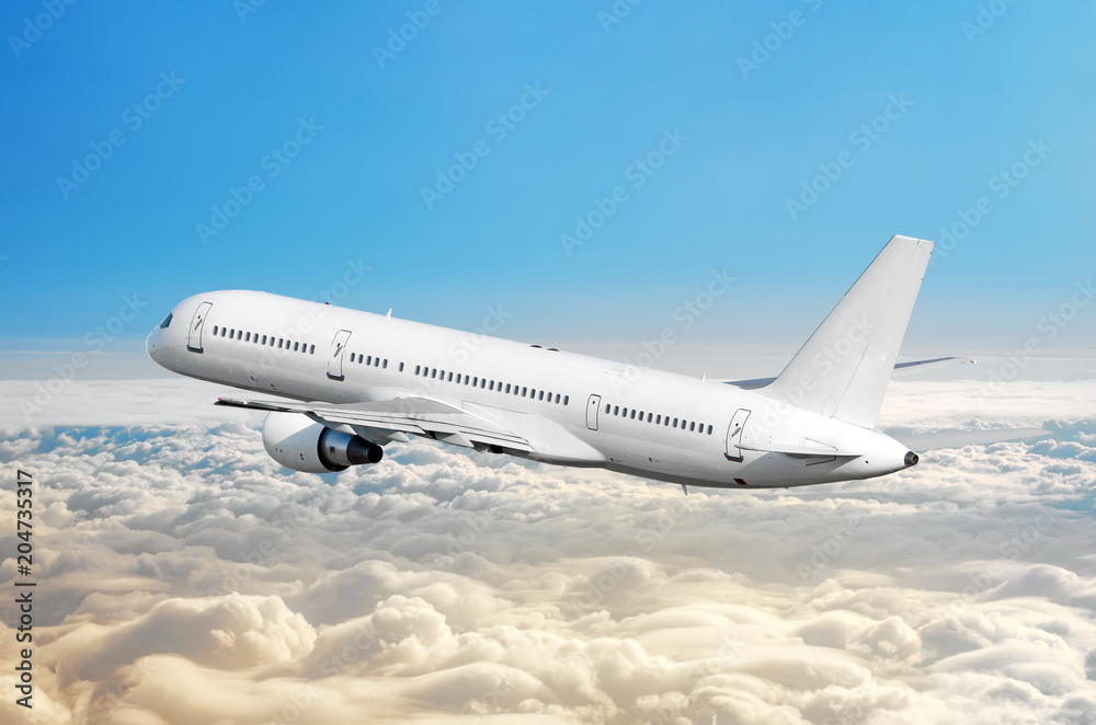 Passenger airplane fly on a hight above overcast clouds and blue sky.