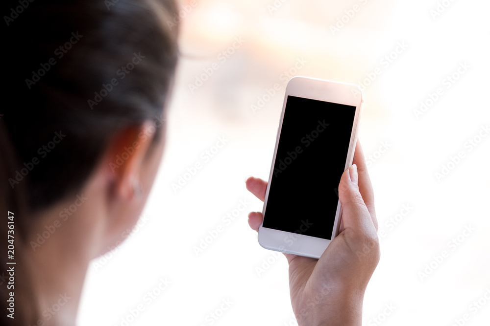 young woman looking at the smartphone, isolated on white background
