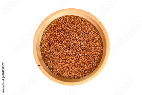 Isolated closeup buckwheat in a round wooden plate