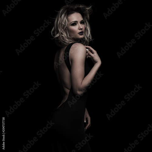sensual woman in open back dress posing on side