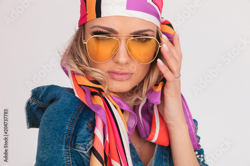 close up of blonde woman with yellow sunglasses and headscarf
