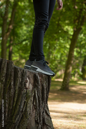 Close up of girl/woman´s sport shoes on the trunk of a tree.