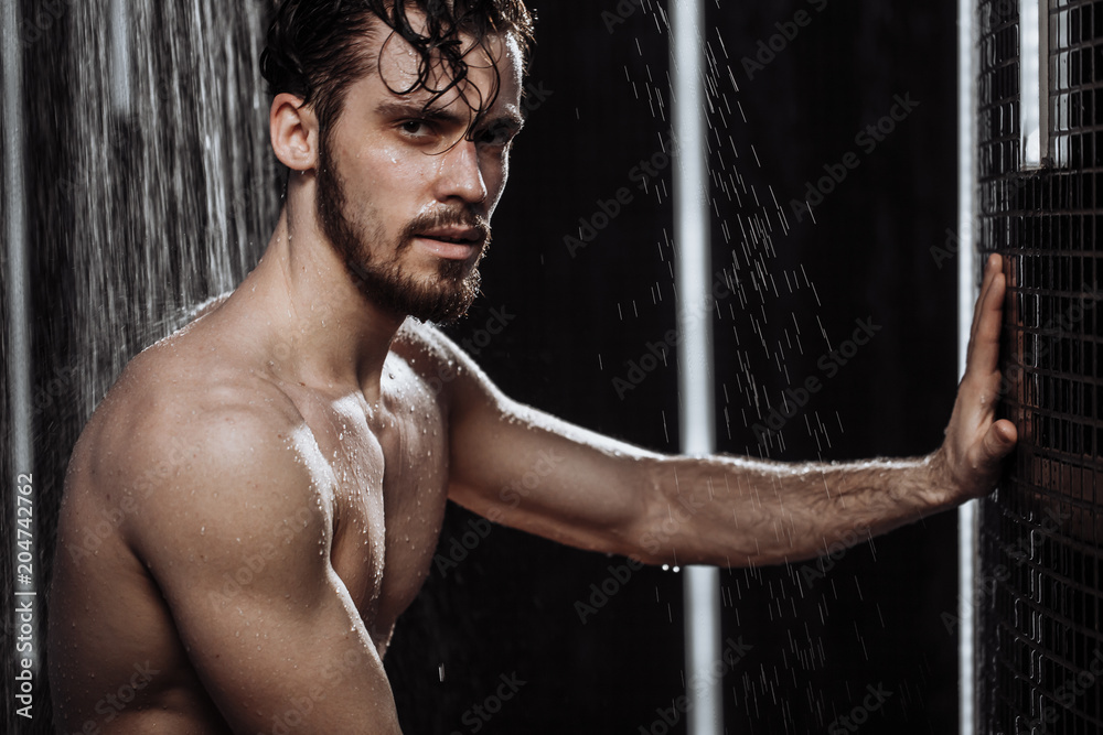 © alfa27 - unshaven male cleansing the body in the douch bath with black walls © alfa27 - unshaven male cleansing the body in the douch bath with black walls