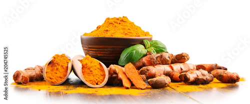 Bowl of turmeric powder over white background