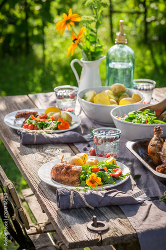 Dinner with chicken and vegetables served in summer garden
