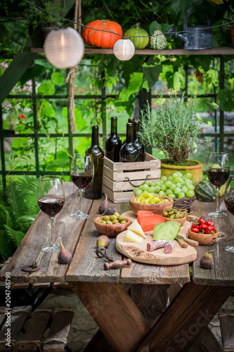 Summer garden table with wine and fruits in the evening
