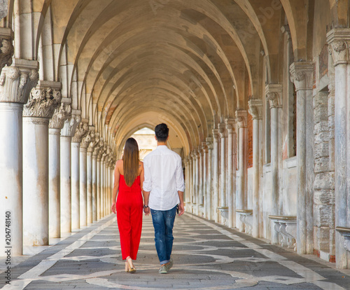 Italy beauty, pretty girl and boy in colonnade on San Marco Square in Venice, Venezia