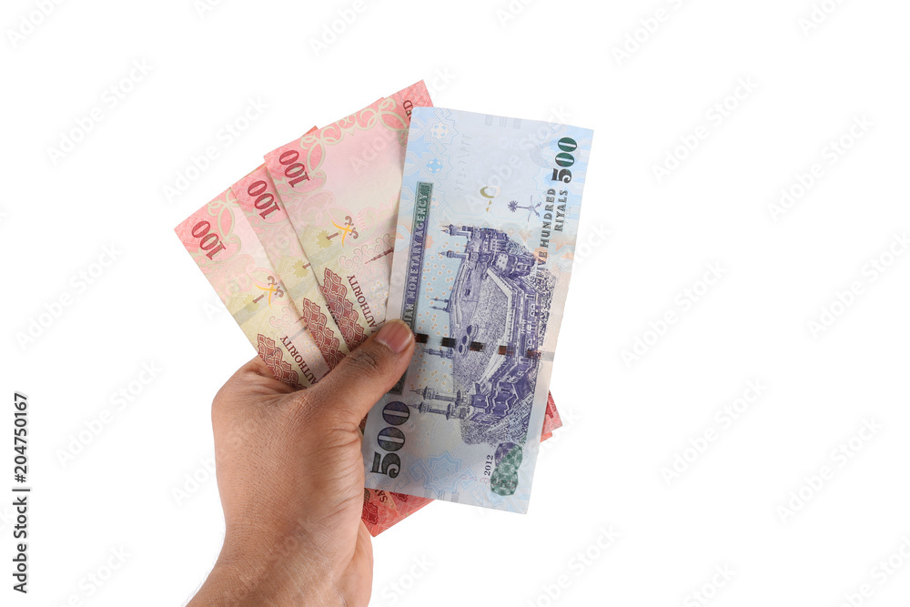 Saudi man counting thousands Saudi Riyal isolated on white background Saudi man counting thousands Saudi Riyal isolated on white background