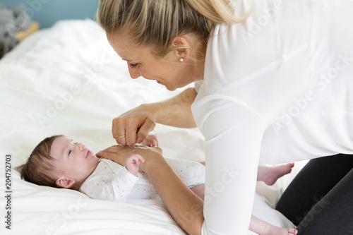 beautiful blond mother, woman massages her baby