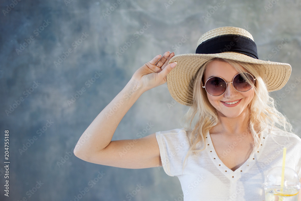 Young beautiful blonde woman in straw hat. Summer style sunglasses. Young beautiful blonde woman in straw hat. Summer style sunglasses.