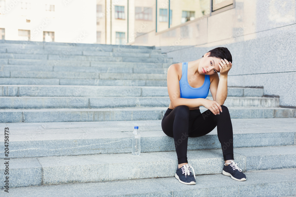 Woman runner is having break on stairs Woman runner is having break on stairs