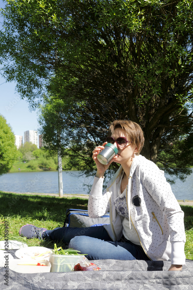 Fototapeta premium Woman has tea on picnic