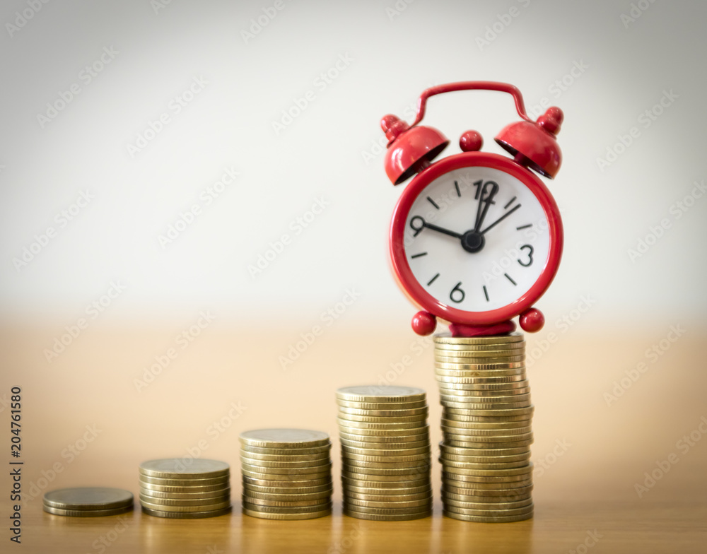 Alarm clock on coin money stacks on a white background.Business concept. Alarm clock on coin money stacks on a white background.Business concept.
