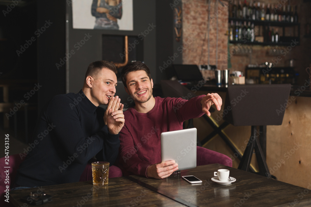 Handsome men using digital tablet at the bar