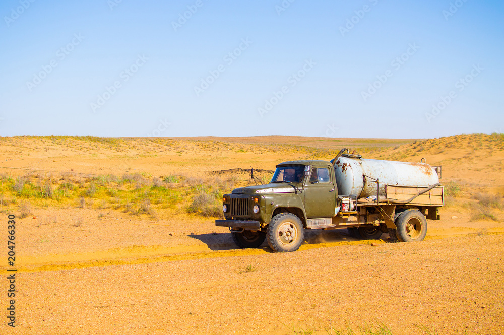 Obraz premium Truck with water tank in sand desert