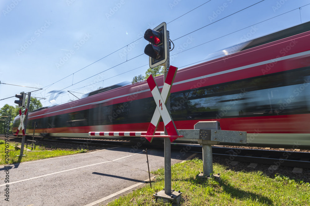 Fototapeta premium Szybki pociąg osobowy przejeżdża przez barierę
