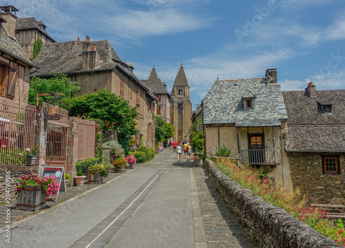 Fototapeta Naklejka Na Ścianę i Meble -  Conques, Midi Pyrenees, France - July 31, 2017: View of Sainte Foy Cathedral at the end of the main street of Conques
