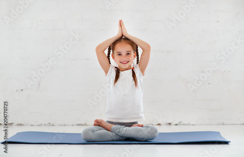 child girl doing yoga and gymnastics in gym