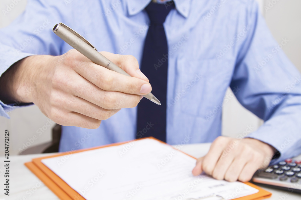 business man's hand with pen to sign document or contract