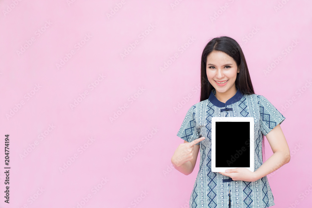 Asian woman holding iPad isolated on pink background Asian woman holding iPad isolated on pink background