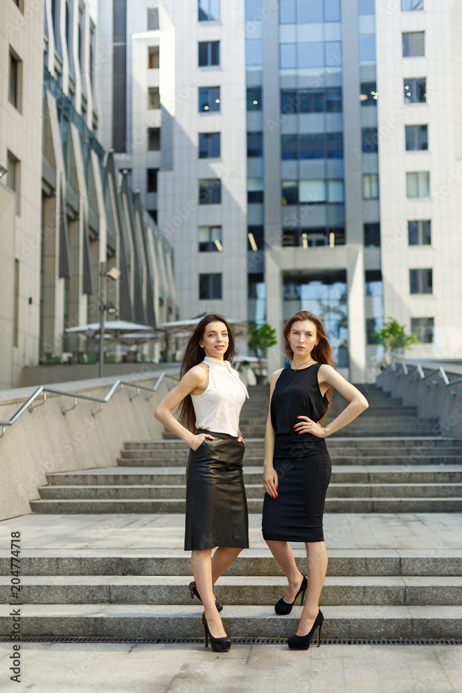 Two business women are negotiating in the background of the city and office center