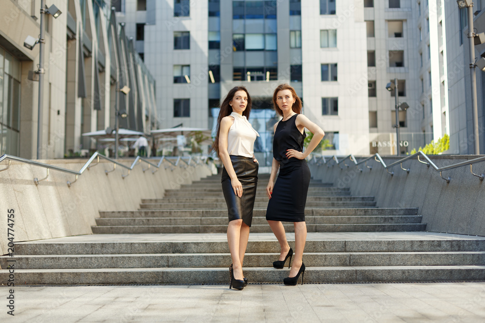 Two business women are negotiating in the background of the city and office center