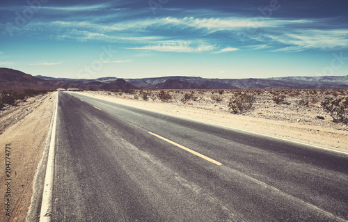 An empty desert road, color toning applied.
