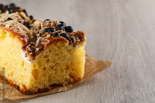cake with almonds and blueberries on wooden table. Closeup. Copyspace
