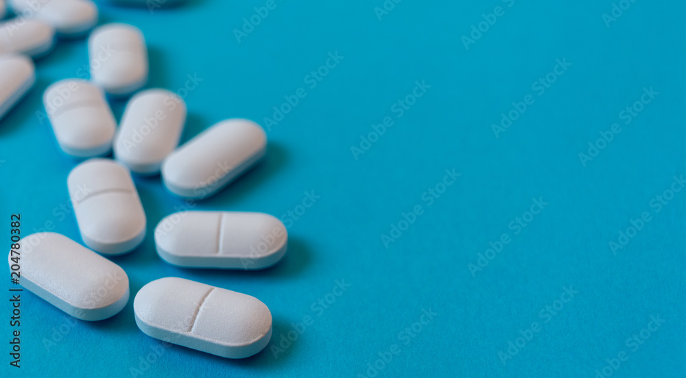 White Oval pills on blue background. Medicine and healthy White Oval pills on blue background. Medicine and healthy