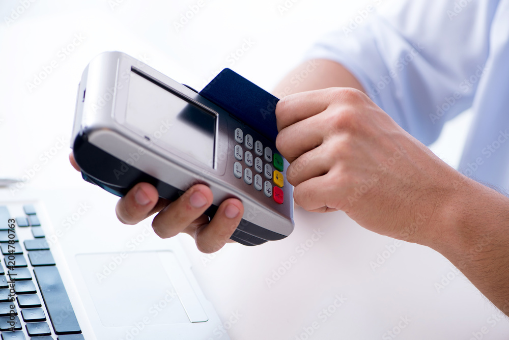 Fototapeta premium Man processing credit card transaction with POS terminal