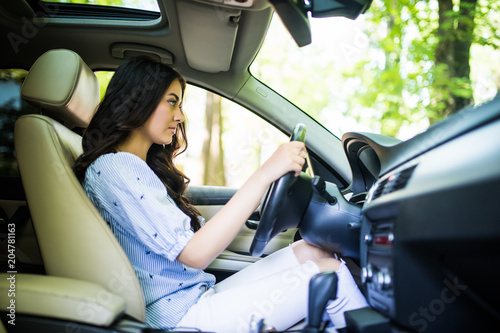 Young woman concentrate in a car on the road