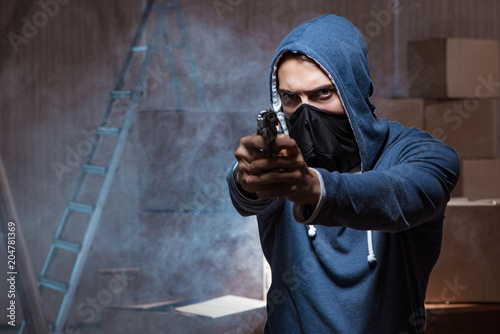 Aggressive manwith gun wearing face mask photo