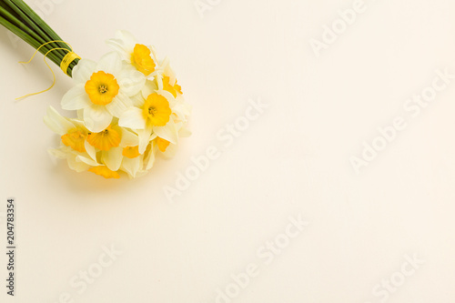 Fototapeta Naklejka Na Ścianę i Meble -  White daffodil bouquet on yellow pastel background with copy space.