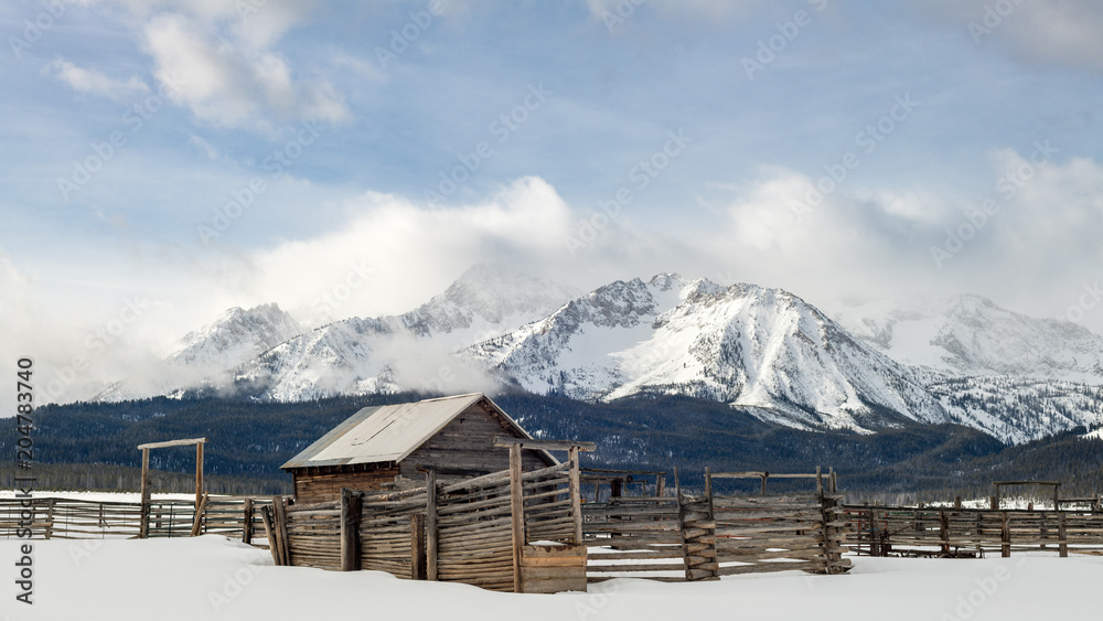 Beautiful Western scene with wood corral and winter Sawtooth Mountains backdrop